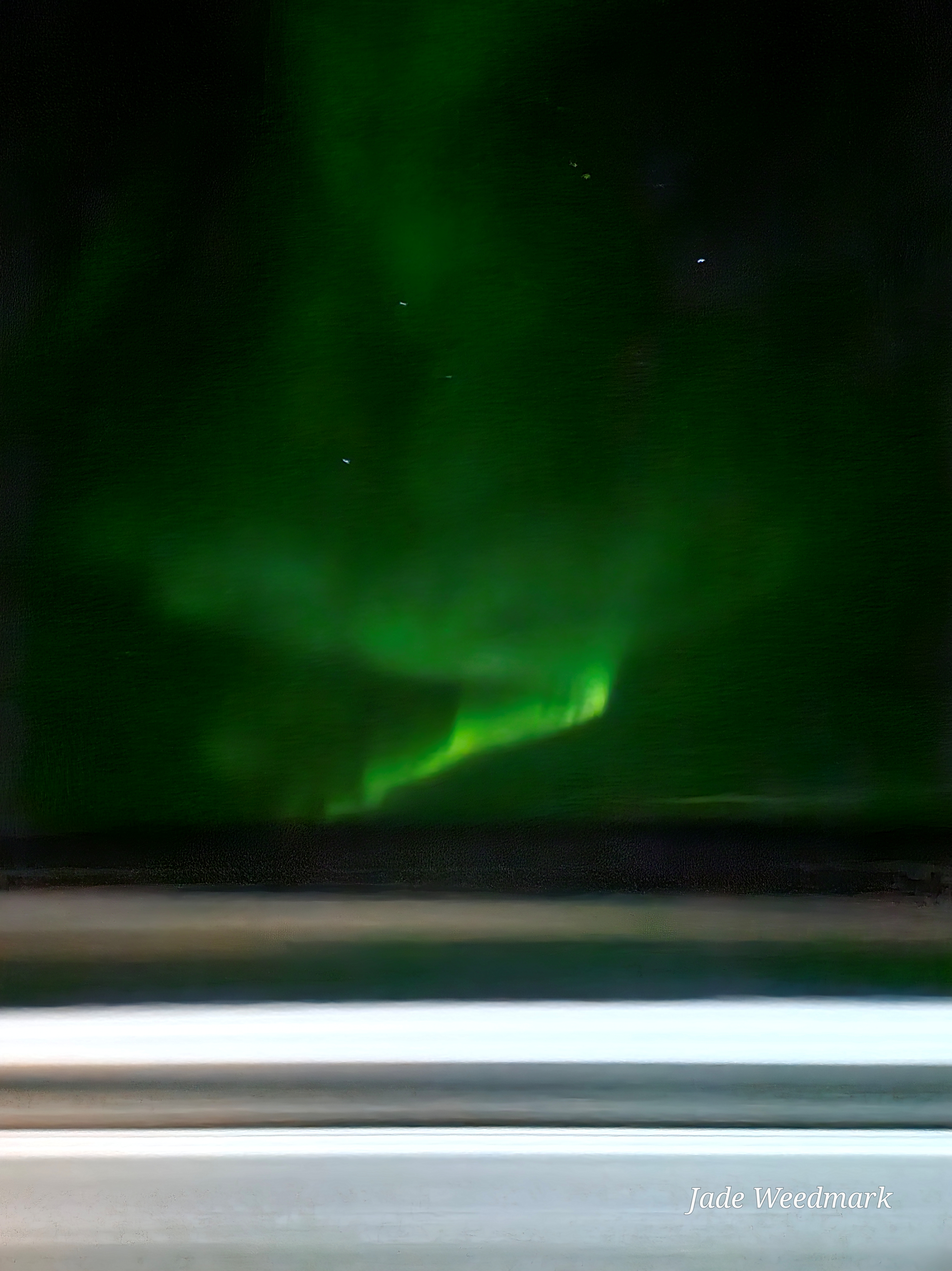 Aurora Borealis sweeping across the sky like God’s brushstrokes on a dark canvas