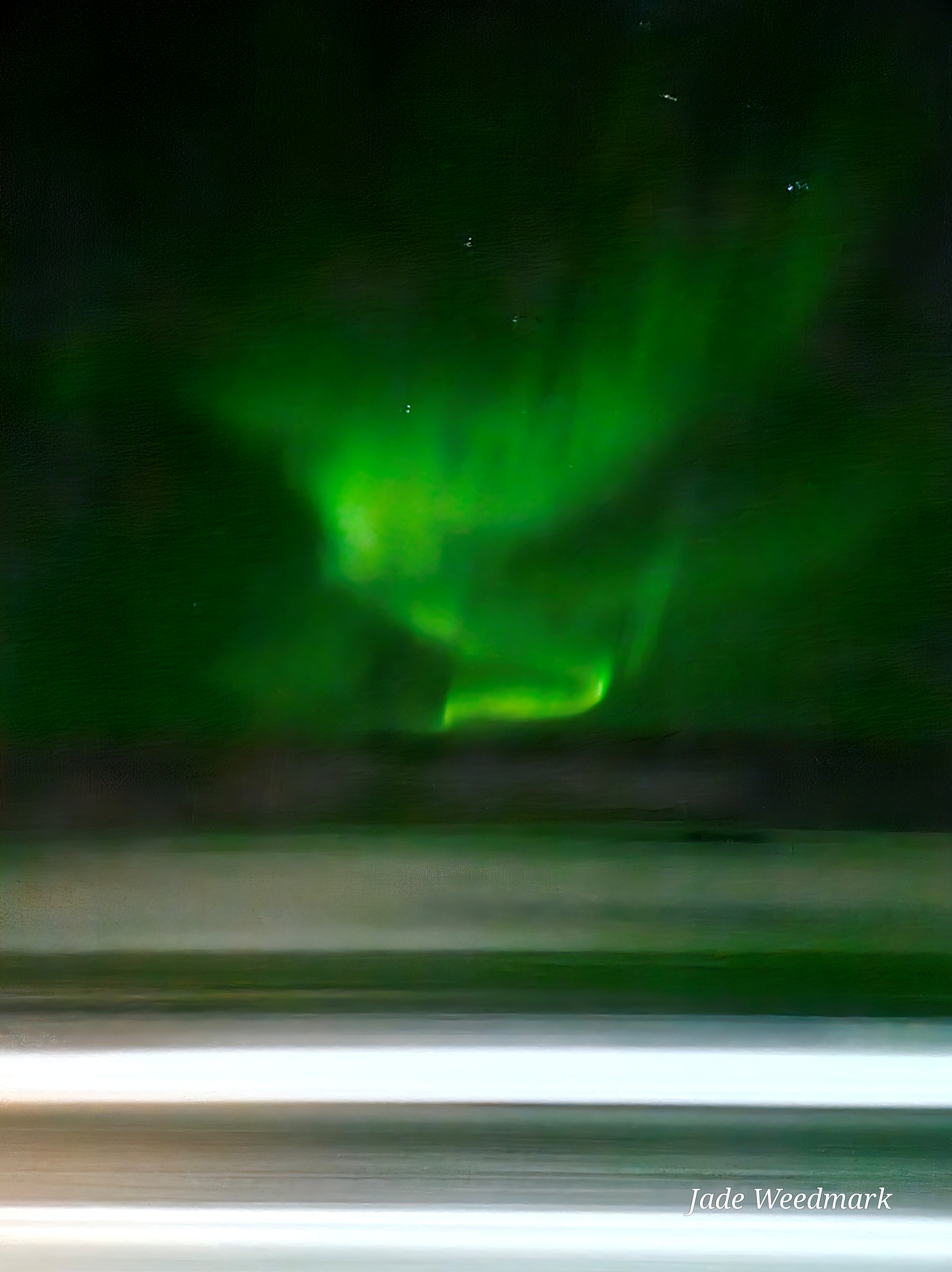 Aurora Borealis sweeping across the sky like God’s brushstrokes on a dark canvas