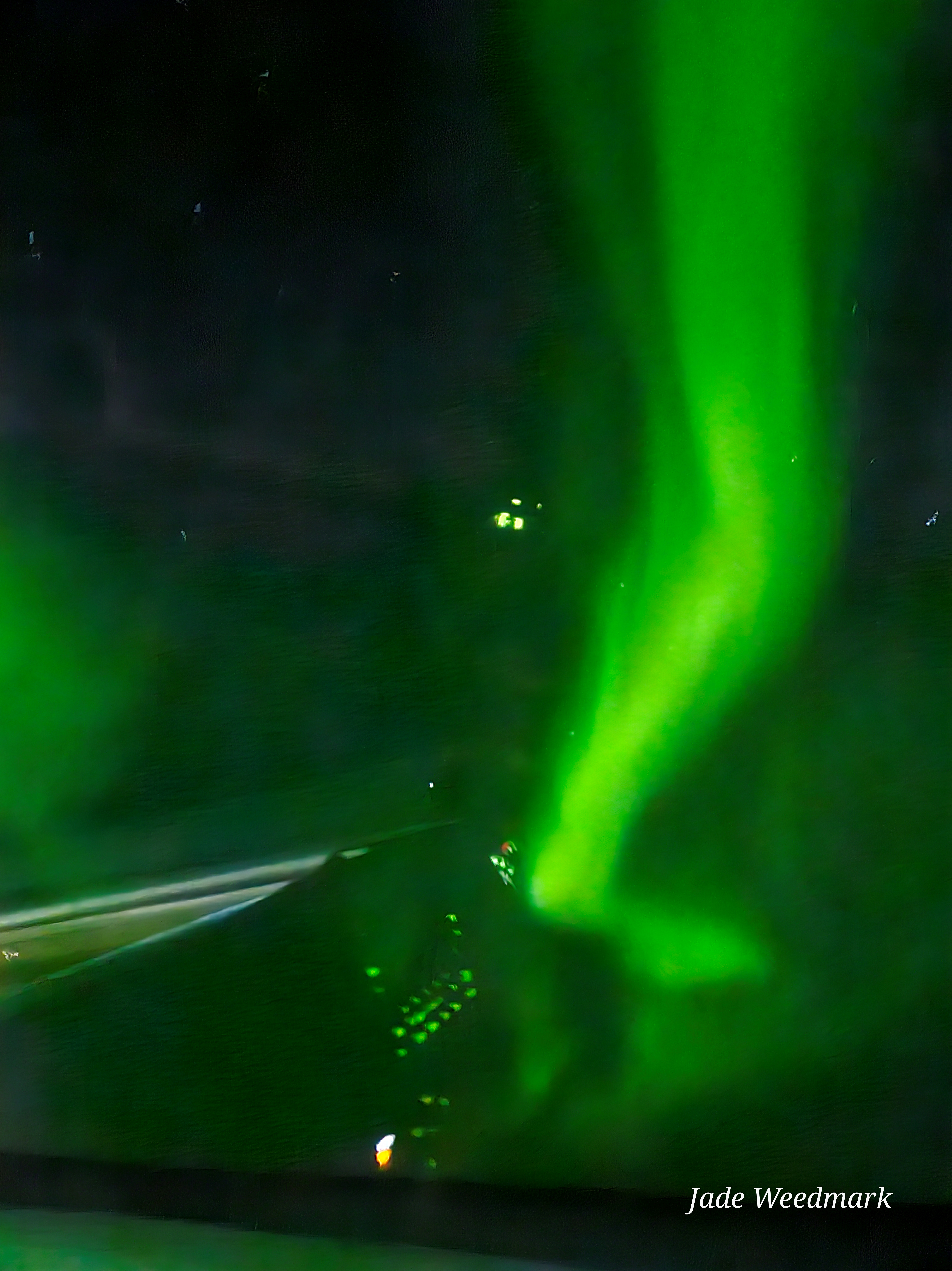 Aurora Borealis sweeping across the sky like God’s brushstrokes on a dark canvas