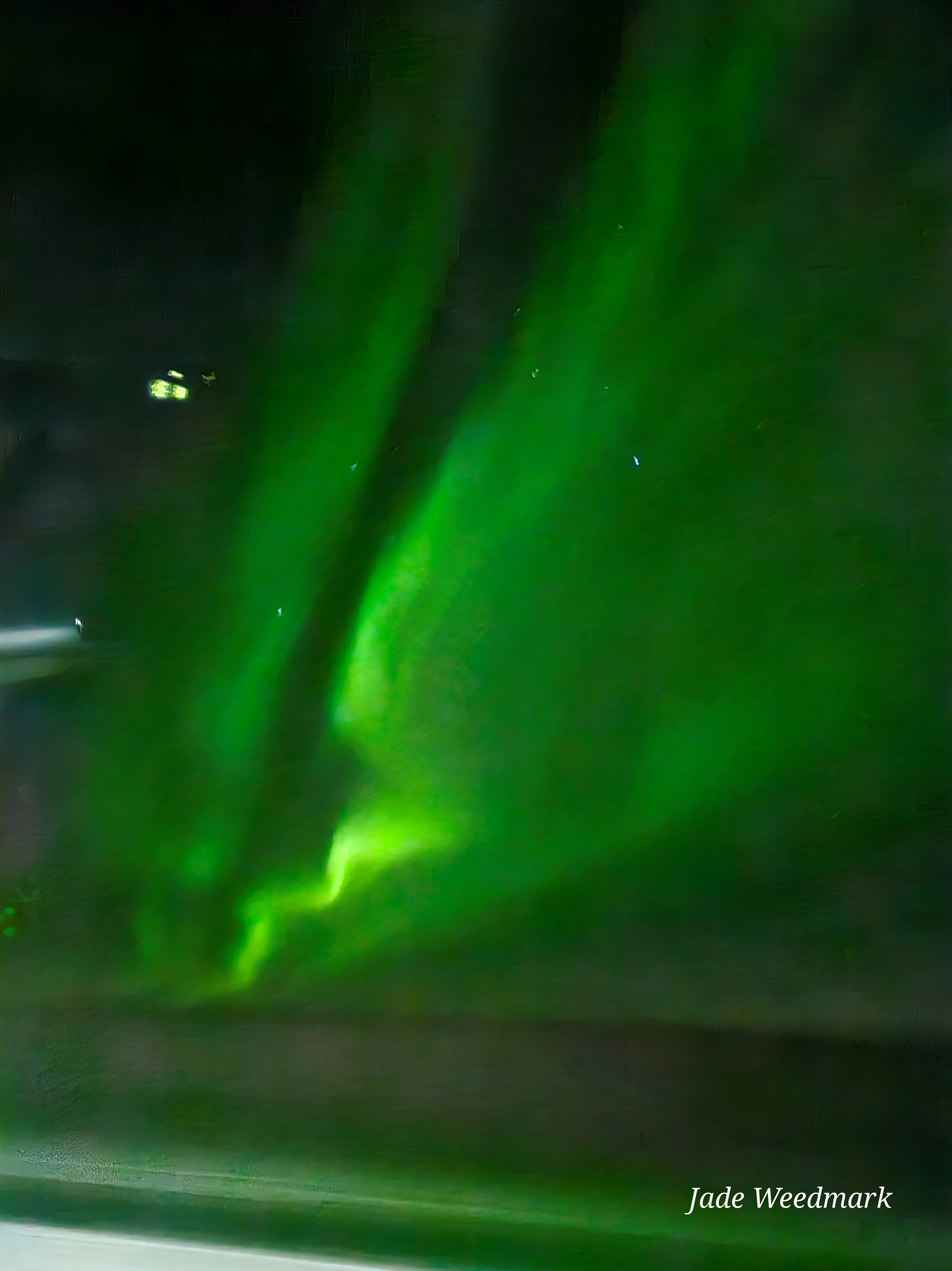 Aurora Borealis sweeping across the sky like God’s brushstrokes on a dark canvas