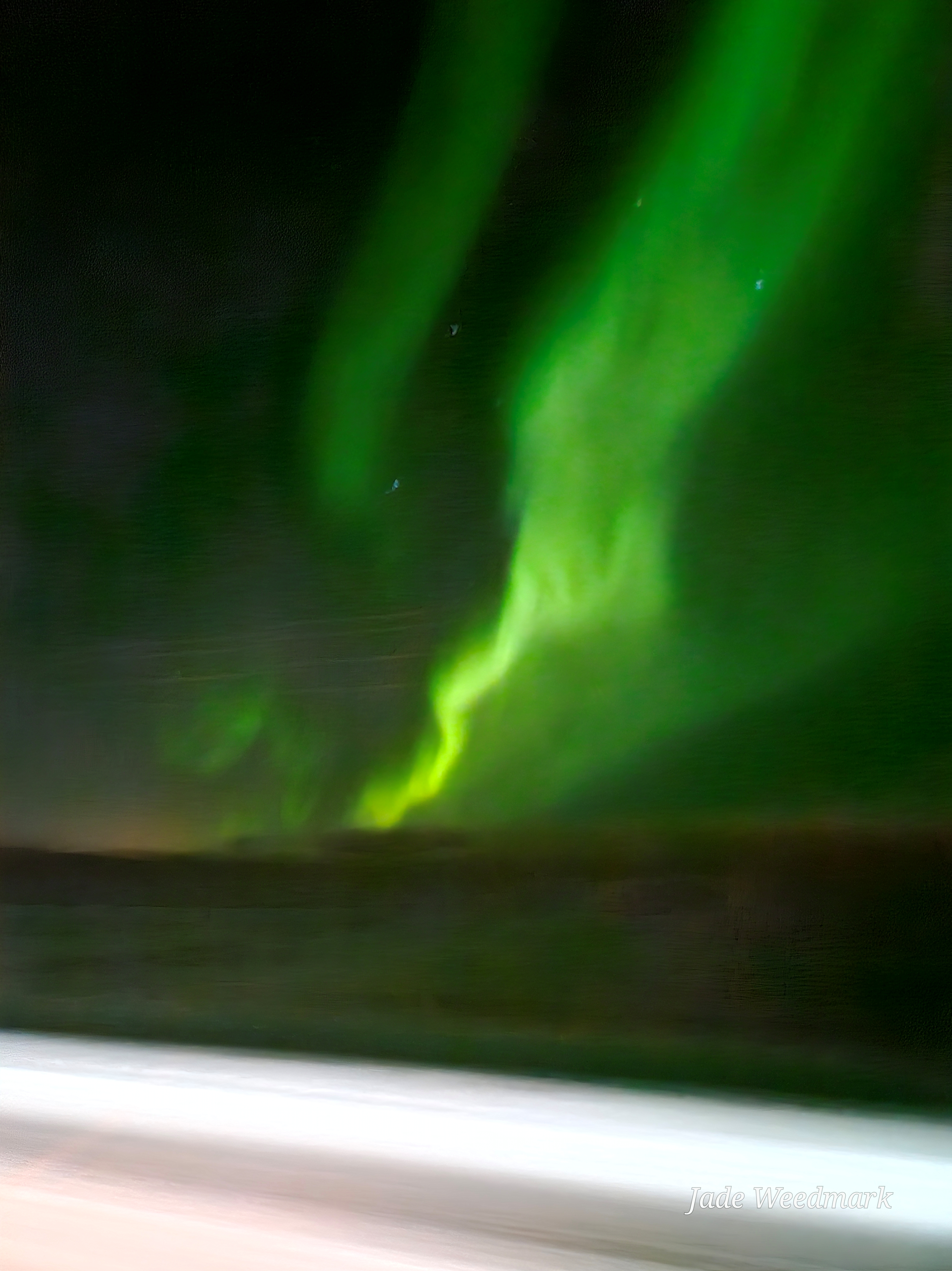 Aurora Borealis sweeping across the sky like God’s brushstrokes on a dark canvas