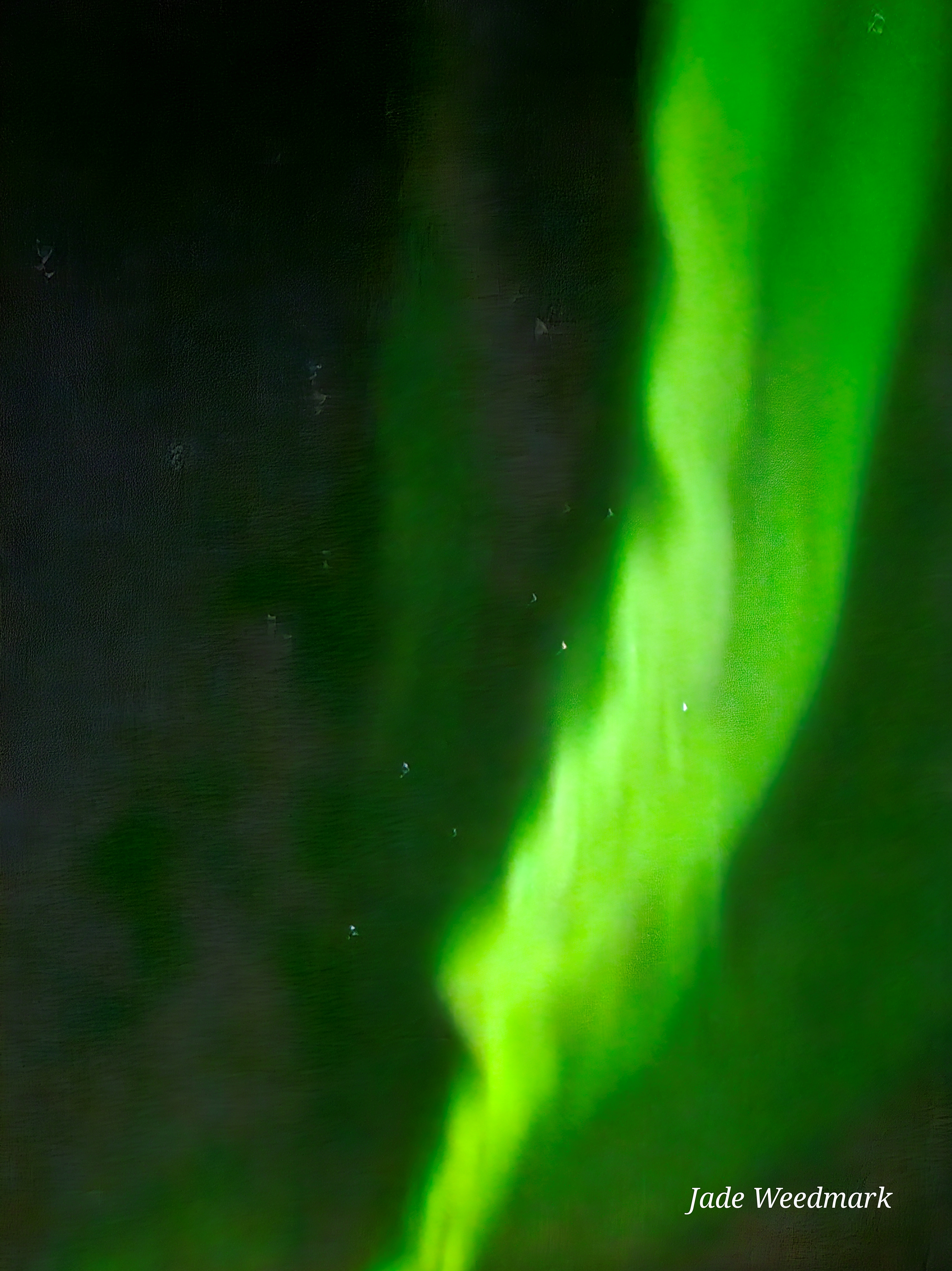 Aurora Borealis sweeping across the sky like God’s brushstrokes on a dark canvas