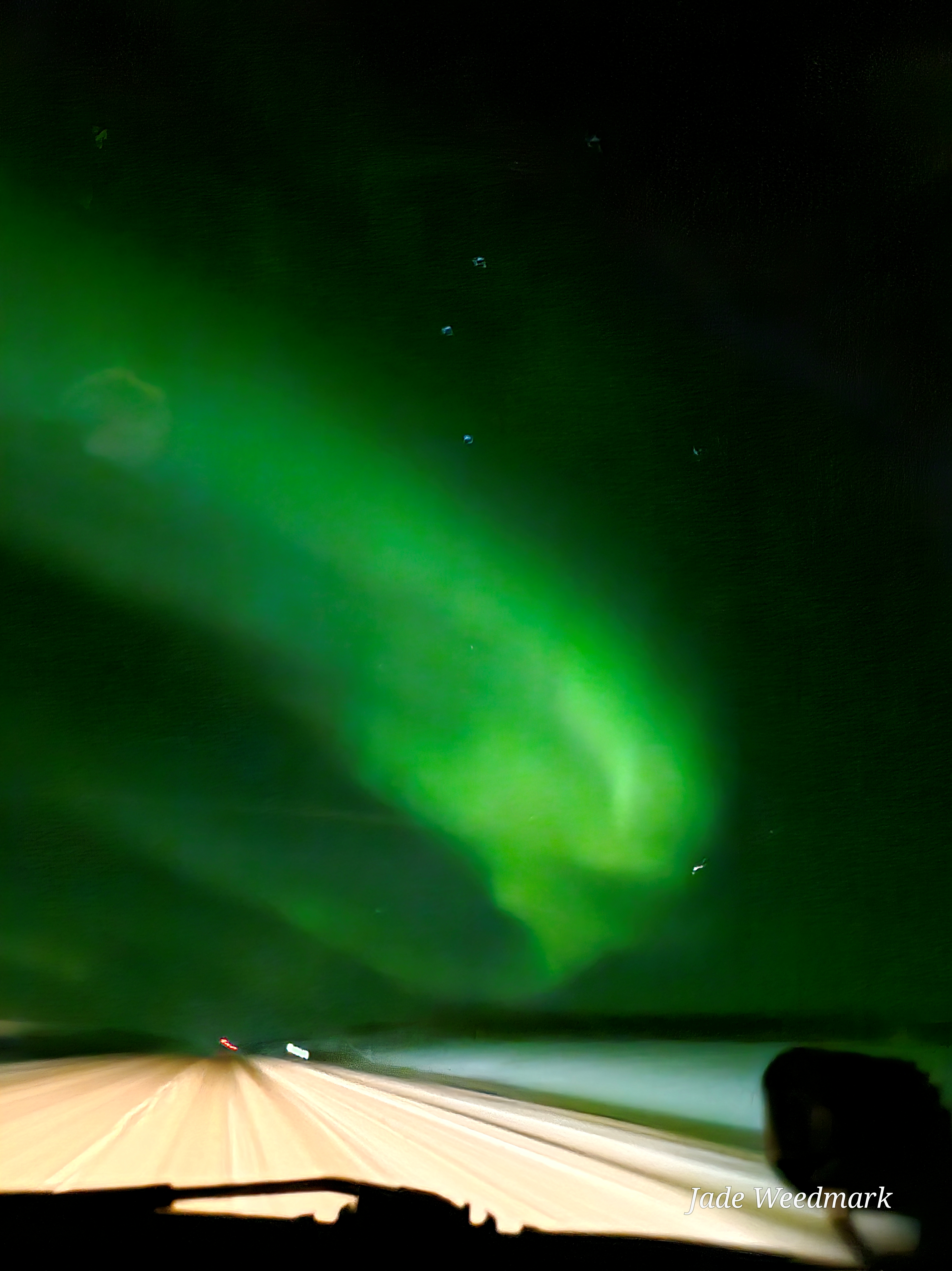 Aurora Borealis sweeping across the sky like God’s brushstrokes on a dark canvas