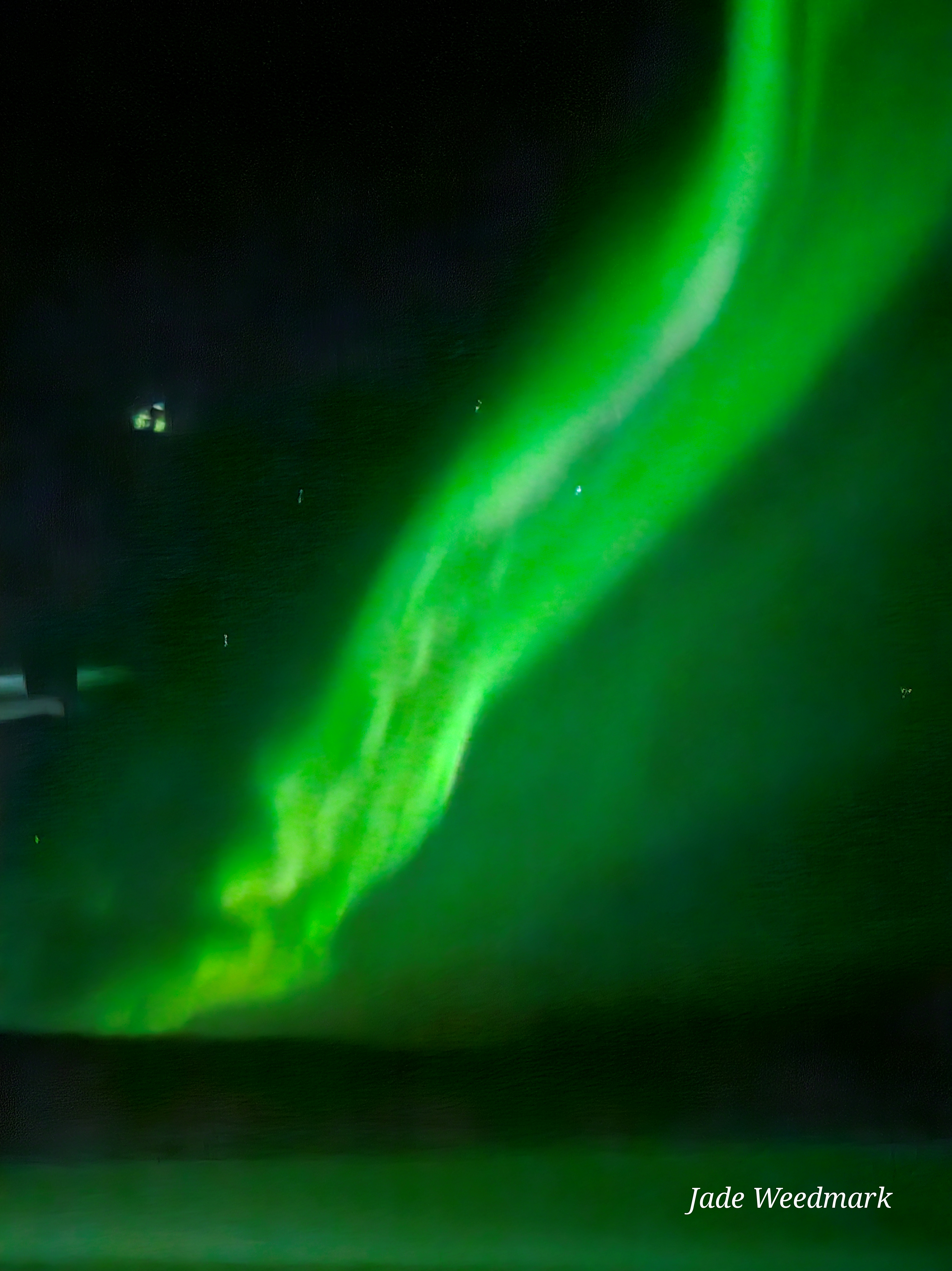 Aurora Borealis sweeping across the sky like God’s brushstrokes on a dark canvas