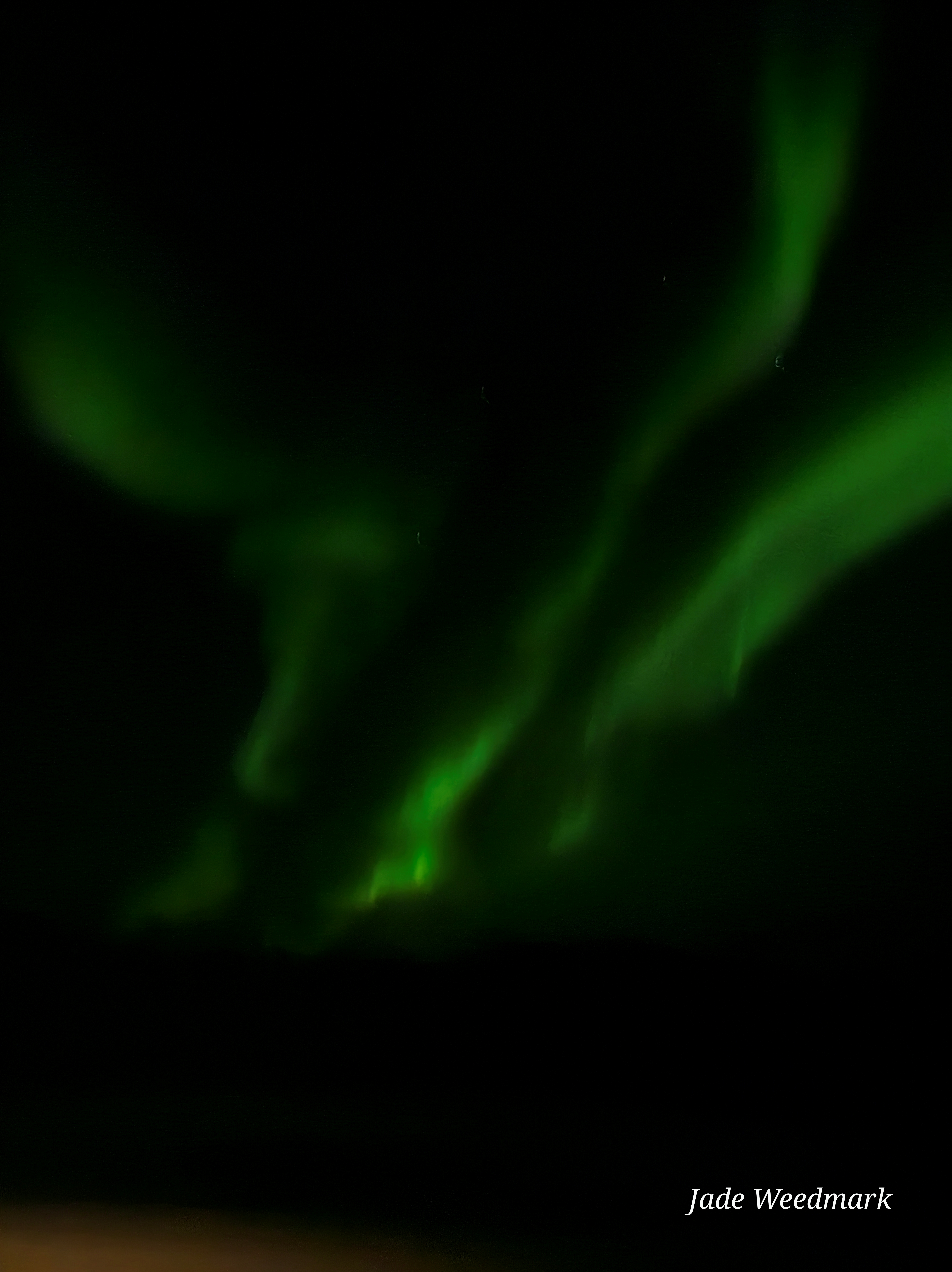 Aurora Borealis sweeping across the sky like God’s brushstrokes on a dark canvas