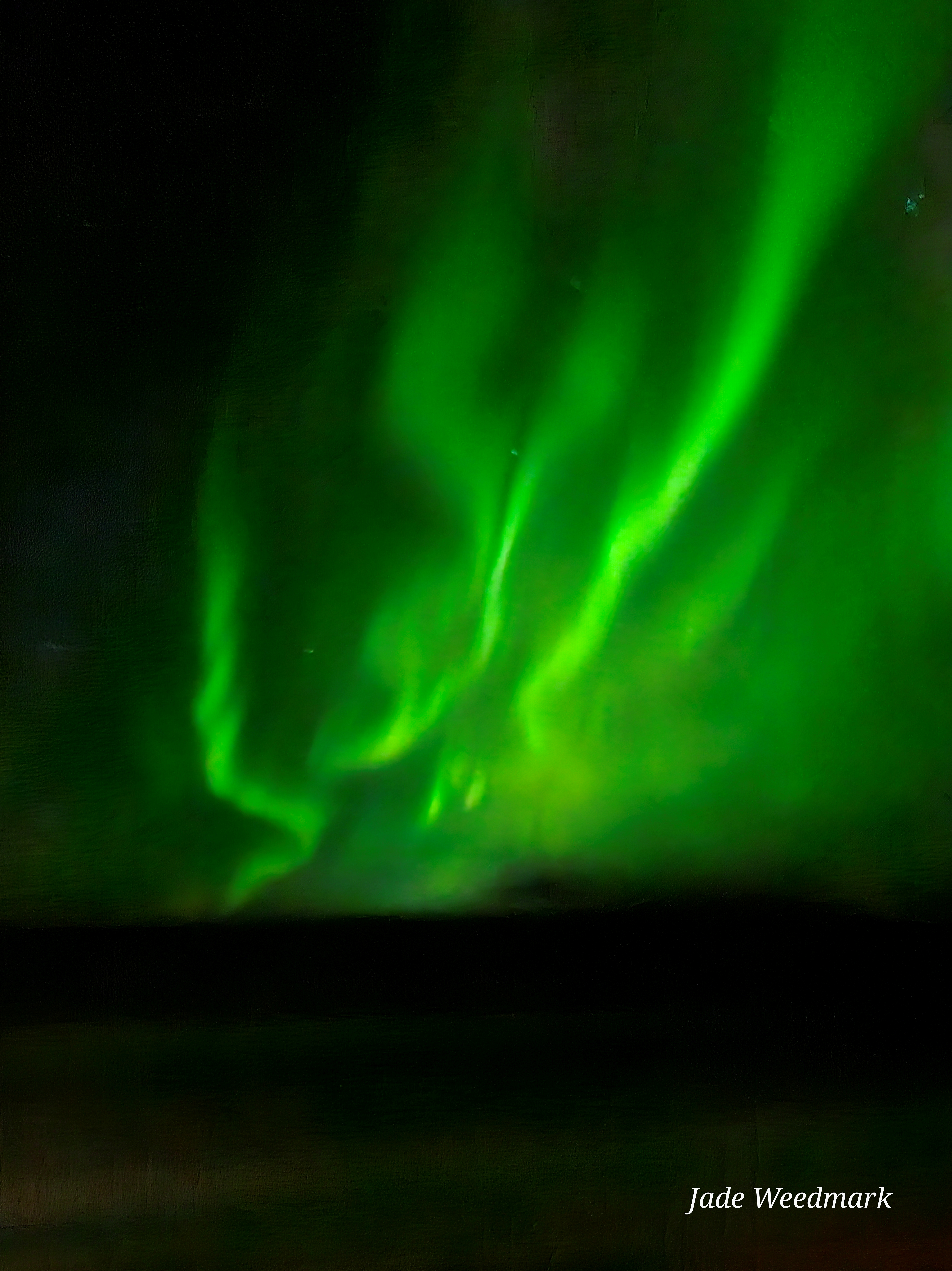 Aurora Borealis sweeping across the sky like God’s brushstrokes on a dark canvas