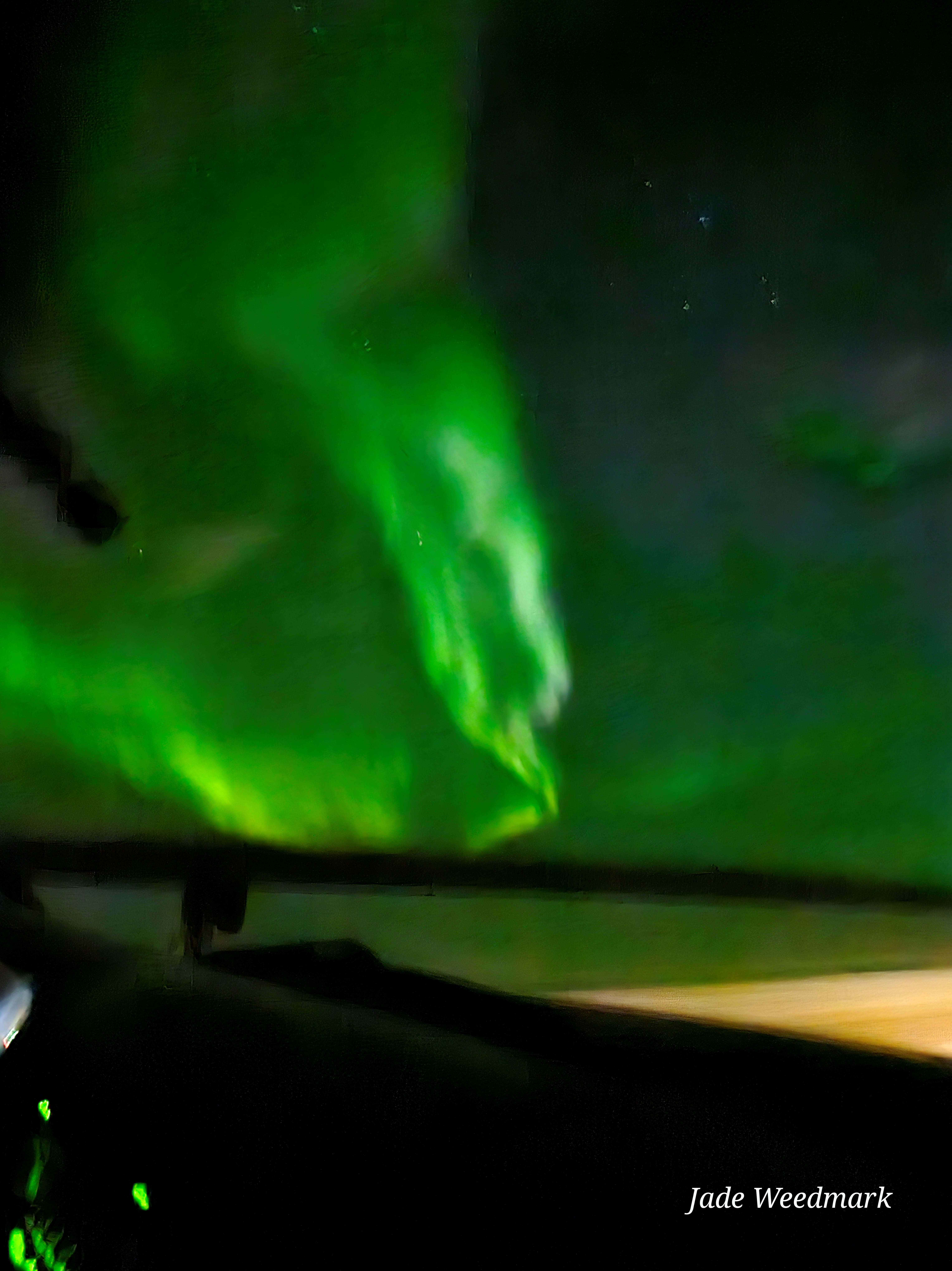 Aurora Borealis sweeping across the sky like God’s brushstrokes on a dark canvas